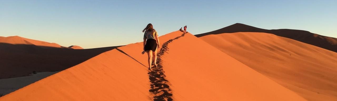 一名GVSU学生走在非洲纳米比亚的沙丘上.